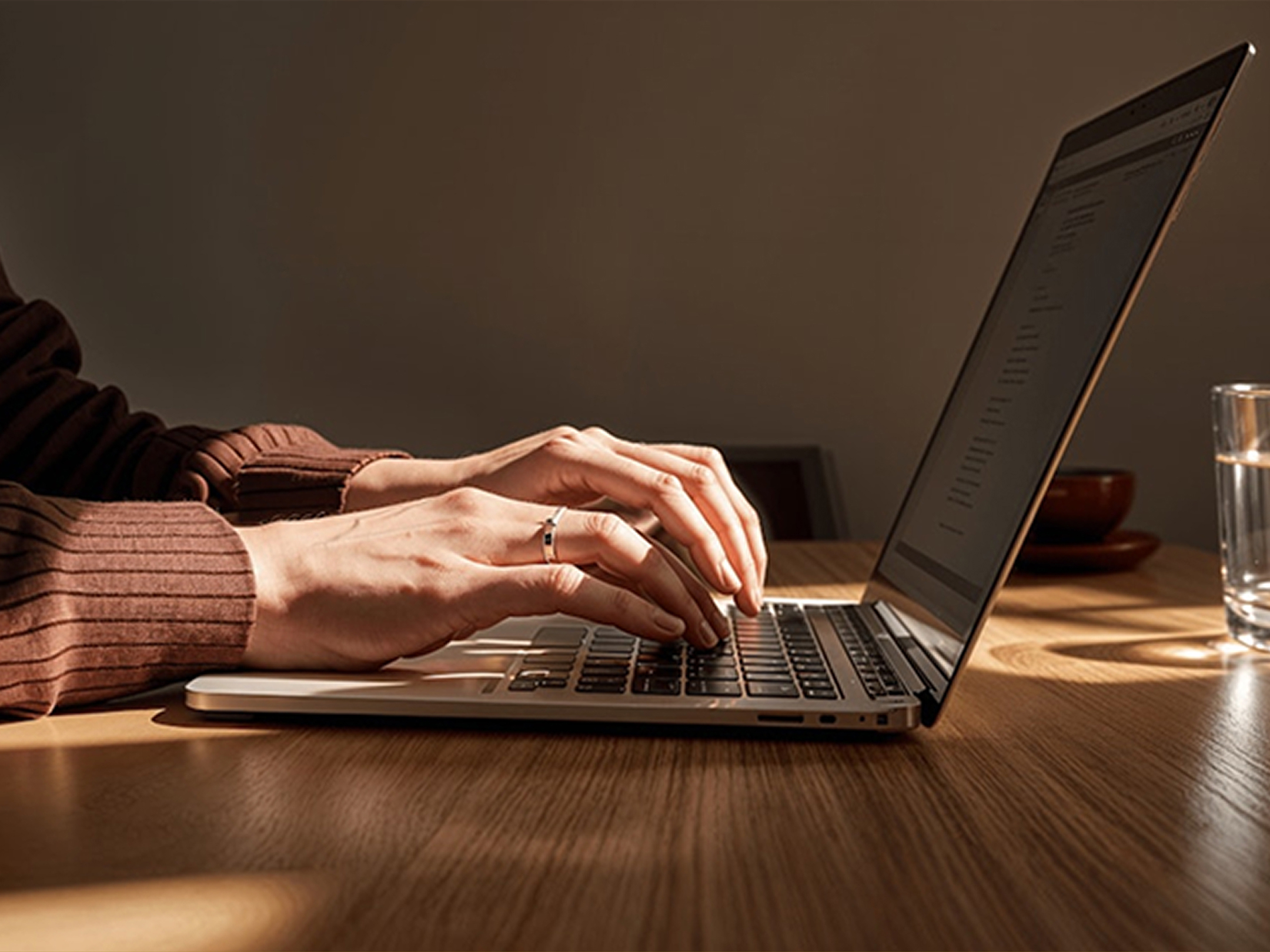 A photo showing hands typing on a laptop keyboard.
